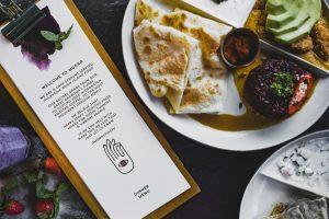 asian island food on plate placed on table with welcome page of cafe menu